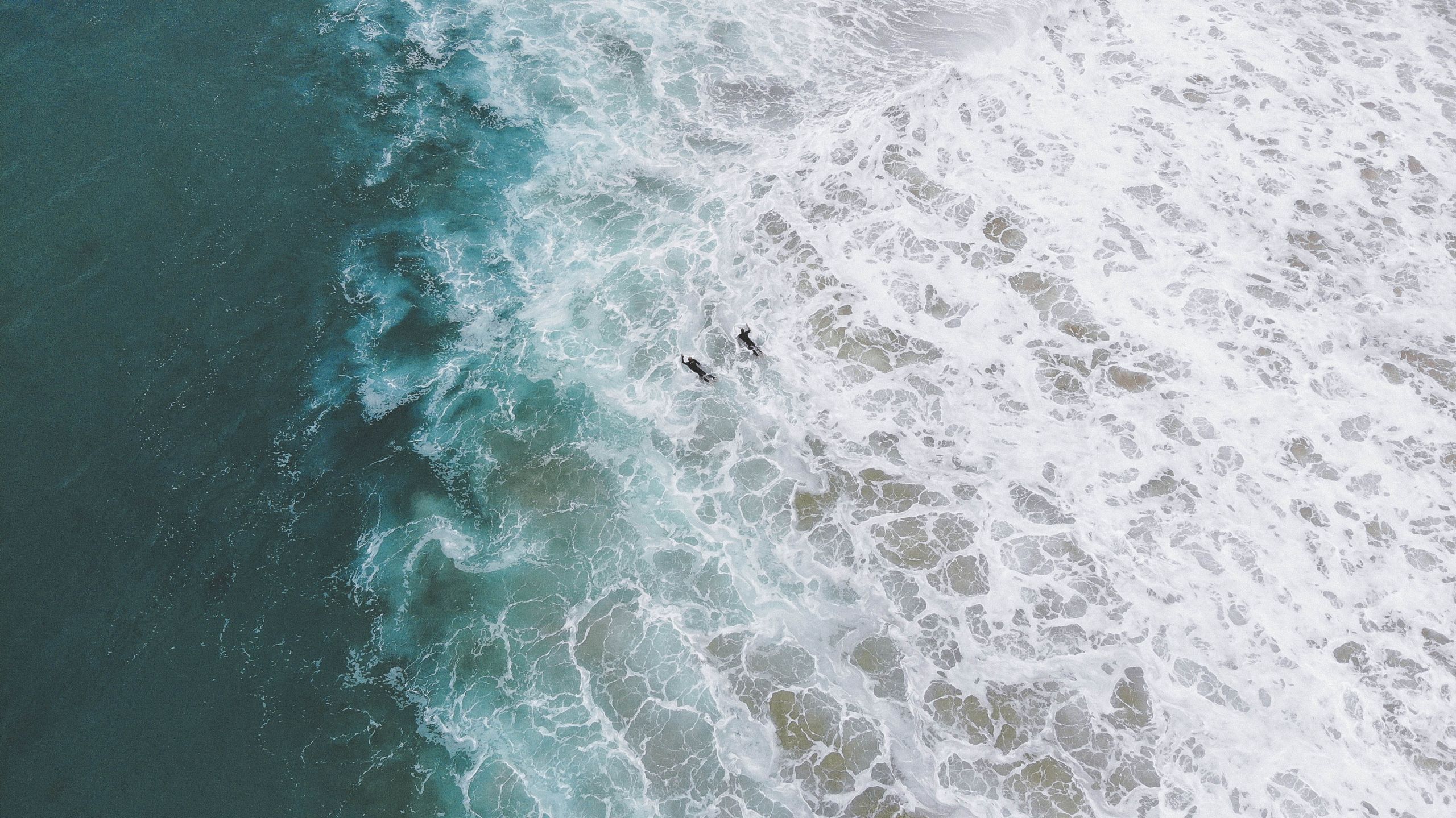 Surfers,Paddling,Through,The,White,Wash,To,The,Blue,Of